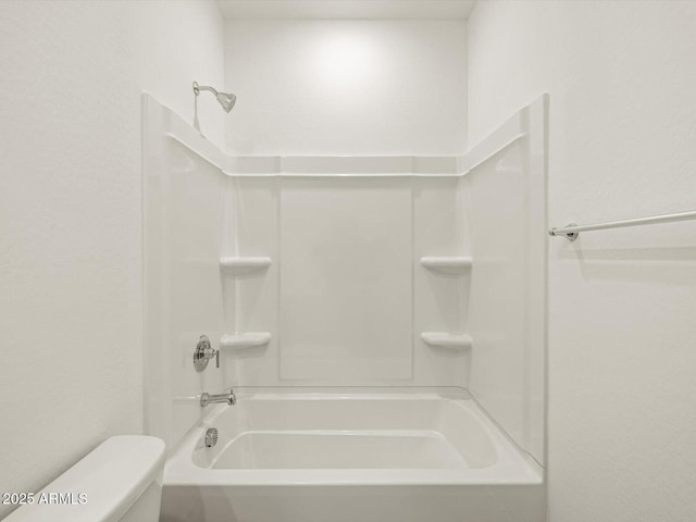 bathroom featuring shower / bathing tub combination and toilet