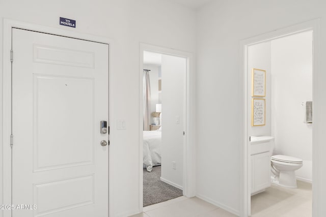 interior space with vanity, baseboards, toilet, and tile patterned flooring