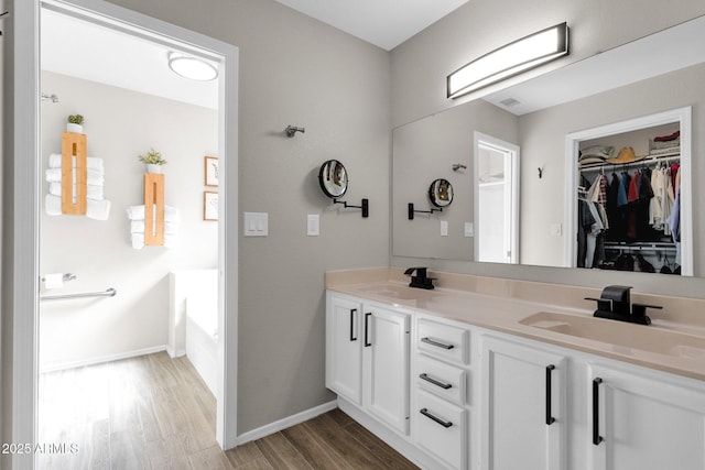 bathroom featuring hardwood / wood-style flooring, vanity, and a tub