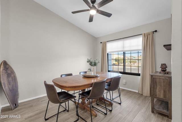 dining area with ceiling fan, vaulted ceiling, and light wood-type flooring