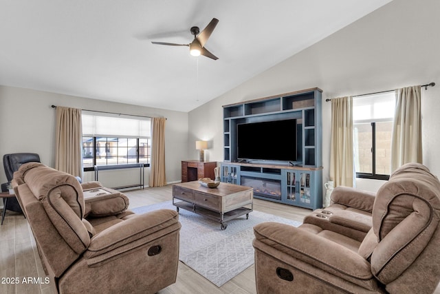 living room featuring light hardwood / wood-style flooring, ceiling fan, and vaulted ceiling