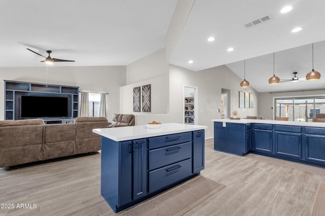 kitchen with decorative light fixtures, blue cabinetry, and a center island