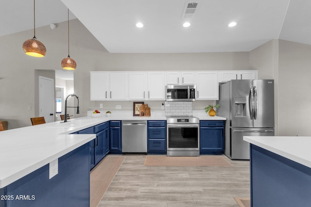 kitchen featuring sink, stainless steel appliances, white cabinets, blue cabinets, and decorative light fixtures