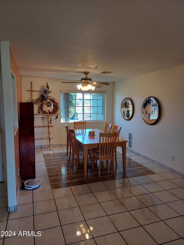 dining area featuring a textured ceiling, tile patterned floors, and ceiling fan