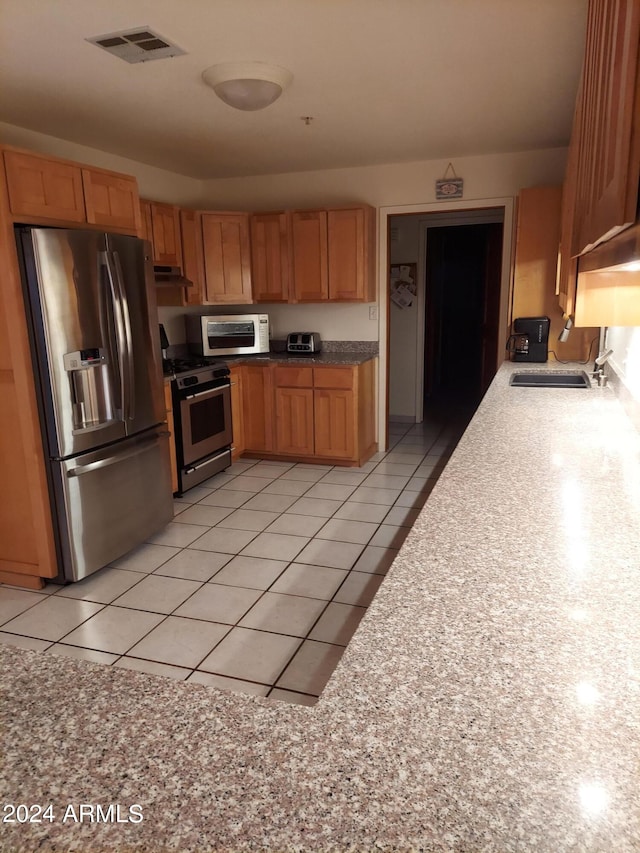 kitchen featuring sink, appliances with stainless steel finishes, and light tile patterned floors