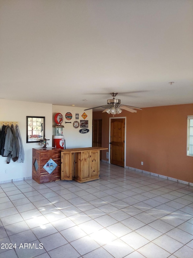 interior space featuring light tile patterned floors and ceiling fan