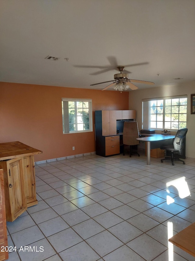 unfurnished living room with light tile patterned floors, a wealth of natural light, and ceiling fan