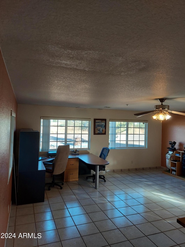 unfurnished office featuring light tile patterned flooring, a textured ceiling, and ceiling fan