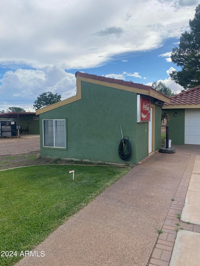 view of side of home featuring a garage and a yard