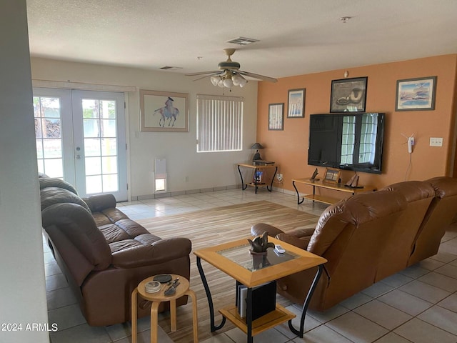 living room featuring tile patterned flooring, a textured ceiling, french doors, and ceiling fan