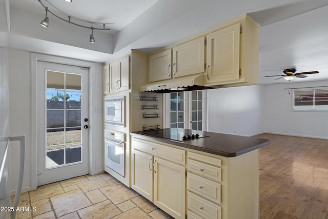 1215 E Geneva Dr, Tempe, AZ 85282 - kitchen with oven, black electric stovetop, under cabinet range hood, cream cabinetry, and dark countertops