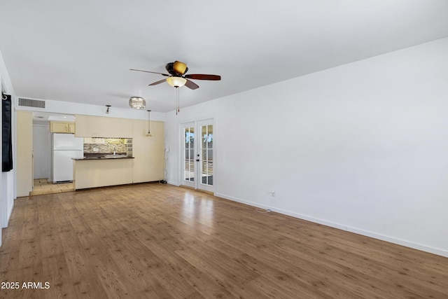 1215 E Geneva Dr, Tempe, AZ 85282 - unfurnished living room featuring french doors, a ceiling fan, light wood-style floors, baseboards, and a sink