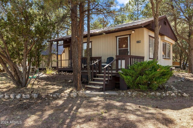 2176 Tenderfoot Trl, Overgaard, AZ 85933 - view of front of house with a wooden deck and metal roof