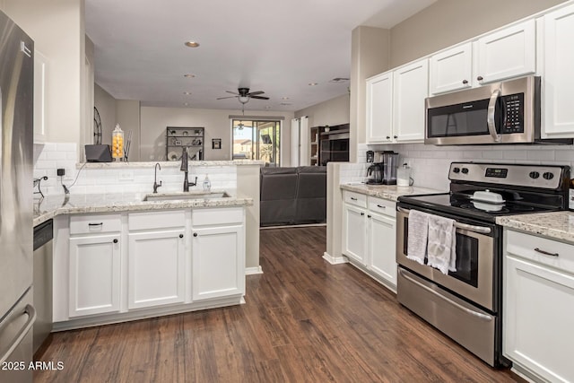 3532 W Mesquite Ave, San Tan Valley, AZ 85144 - kitchen featuring appliances with stainless steel finishes, a peninsula, tasteful backsplash, white cabinets, and recessed lighting
