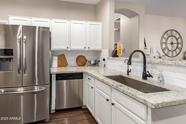 3532 W Mesquite Ave, San Tan Valley, AZ 85144 - kitchen featuring appliances with stainless steel finishes, arched walkways, light stone counters, and backsplash
