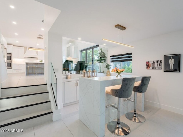 4748 E Redfield Rd, Phoenix, AZ 85032 - kitchen with custom exhaust hood, white cabinets, a kitchen breakfast bar, light countertops, and light tile patterned flooring