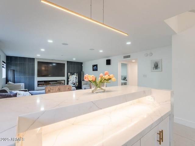 4748 E Redfield Rd, Phoenix, AZ 85032 - kitchen with light stone countertops, open floor plan, white cabinets, recessed lighting, and baseboards
