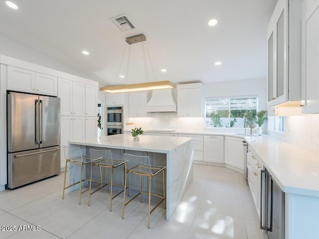 4748 E Redfield Rd, Phoenix, AZ 85032 - kitchen with appliances with stainless steel finishes, custom range hood, a spacious island, tasteful backsplash, and recessed lighting
