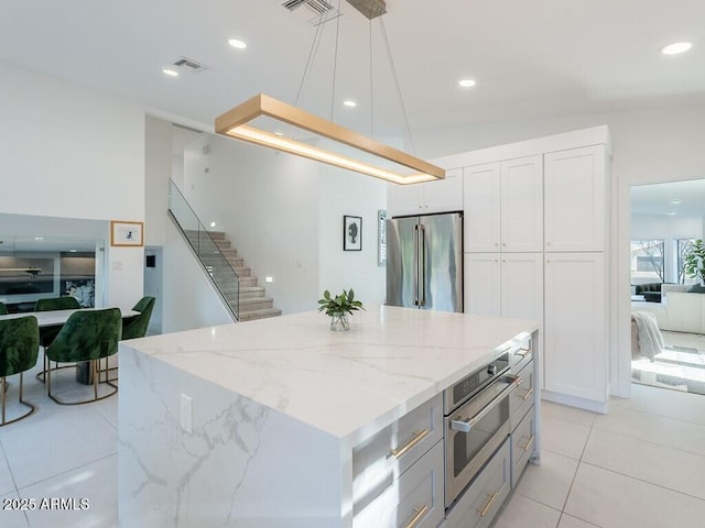 4748 E Redfield Rd, Phoenix, AZ 85032 - kitchen with appliances with stainless steel finishes, light tile patterned floors, light stone countertops, decorative light fixtures, and white cabinets