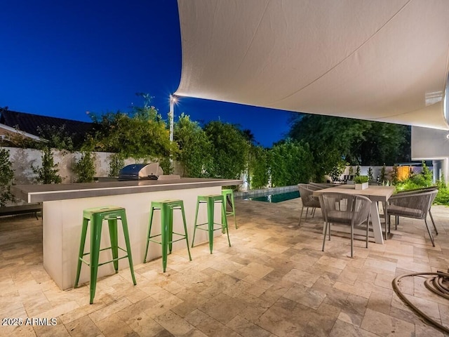 4748 E Redfield Rd, Phoenix, AZ 85032 - patio at twilight featuring an outdoor bar, exterior kitchen, a patio area, and outdoor dining space