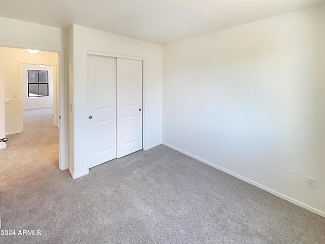 unfurnished bedroom with carpet flooring and a closet