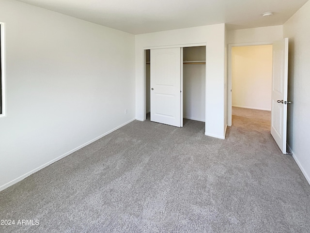 unfurnished bedroom featuring carpet flooring and a closet