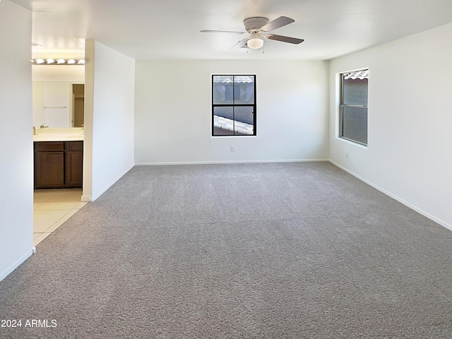 empty room featuring ceiling fan and light carpet