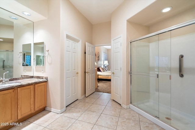 ensuite bathroom featuring vanity, baseboards, tile patterned flooring, a shower stall, and connected bathroom