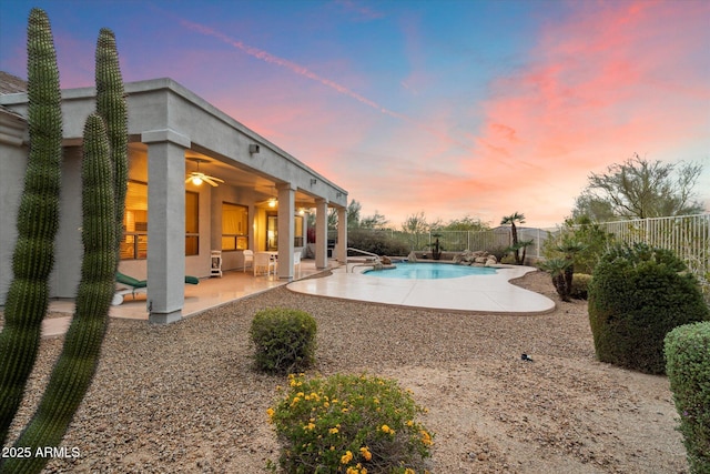 pool at dusk featuring a patio, a ceiling fan, a fenced in pool, and a fenced backyard