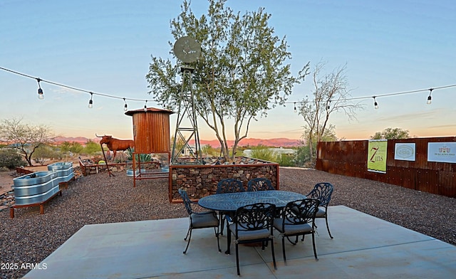 patio terrace at dusk featuring outdoor dining area