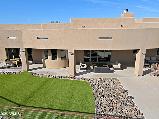 exterior space featuring an outdoor living space, stucco siding, a patio, and a lawn