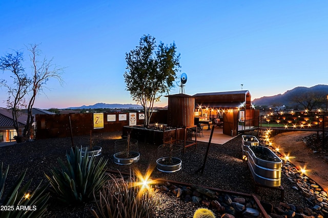 view of yard with a mountain view, fence, a fire pit, and a patio area