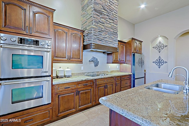 kitchen with light stone countertops, arched walkways, a sink, extractor fan, and appliances with stainless steel finishes