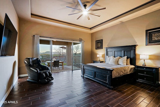 bedroom featuring access to exterior, baseboards, wood tiled floor, a raised ceiling, and a ceiling fan