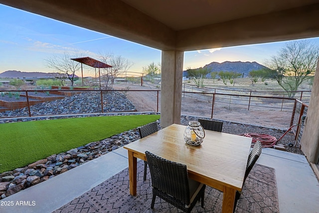 view of patio with a mountain view, outdoor dining area, and a fenced backyard