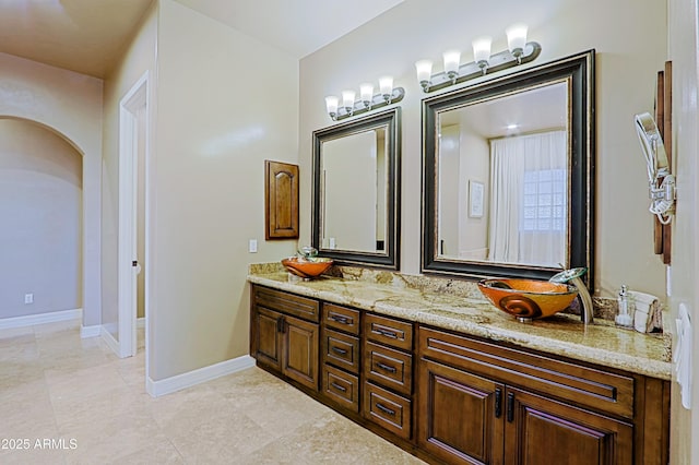 bathroom featuring baseboards and vanity