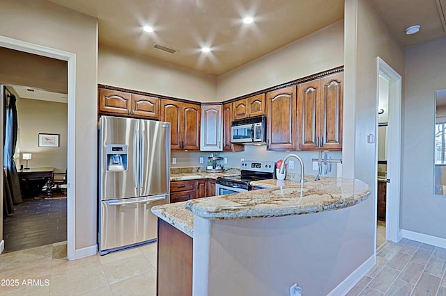 kitchen with visible vents, light stone counters, recessed lighting, a peninsula, and stainless steel appliances