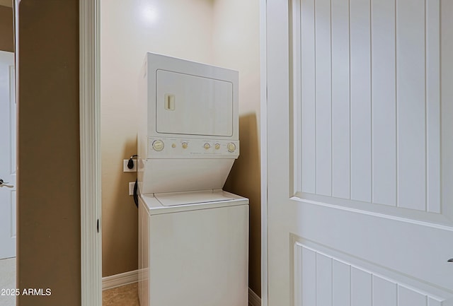 laundry area with baseboards, stacked washer and clothes dryer, and laundry area