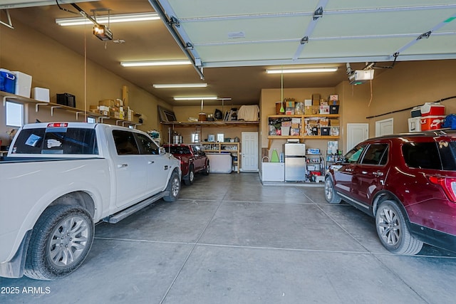 garage featuring a garage door opener and freestanding refrigerator