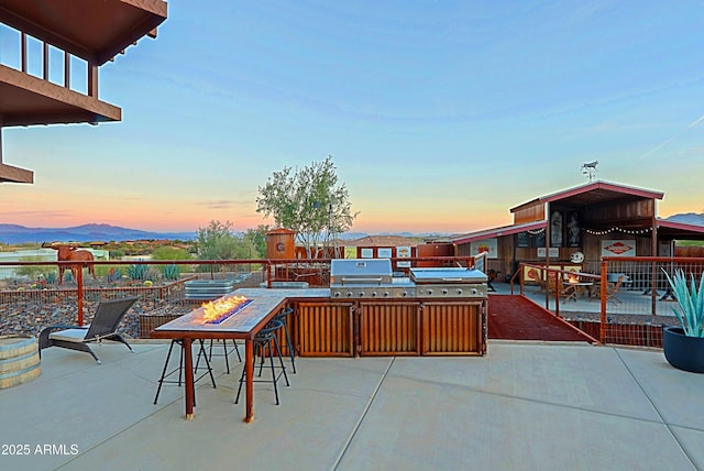 view of patio with area for grilling and an outdoor fire pit