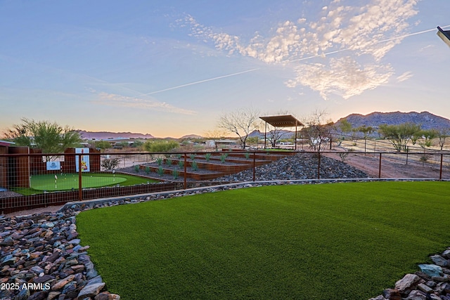 yard at dusk with fence and a mountain view