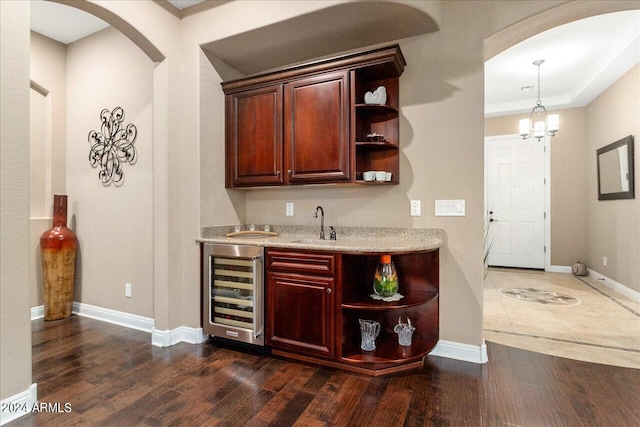 bar featuring sink, hanging light fixtures, dark hardwood / wood-style floors, wine cooler, and a chandelier