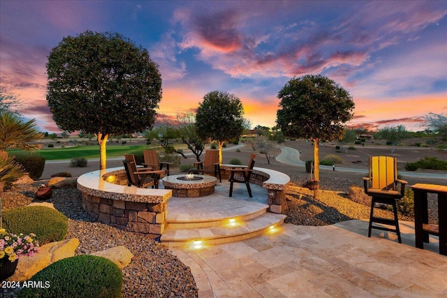 patio terrace at dusk featuring an outdoor fire pit