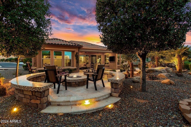 patio terrace at dusk featuring an outdoor fire pit