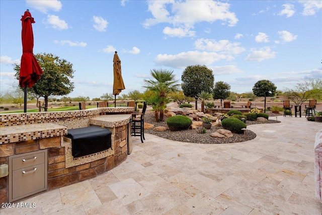 view of patio with a bar and area for grilling