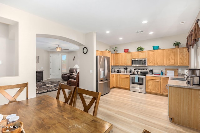 kitchen with sink, light hardwood / wood-style flooring, ceiling fan, and appliances with stainless steel finishes