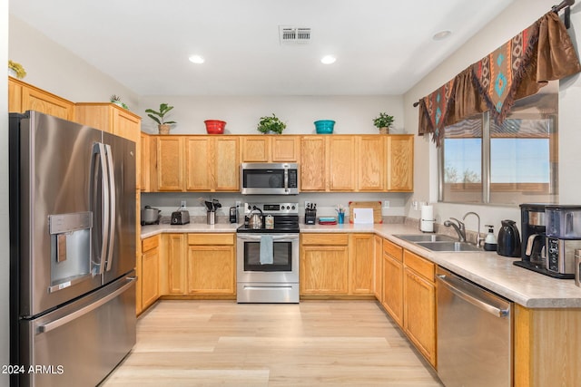 kitchen with light hardwood / wood-style floors, sink, light brown cabinets, and stainless steel appliances