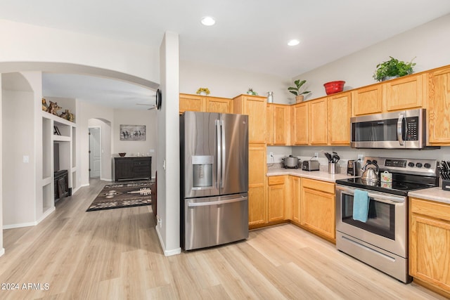 kitchen with light hardwood / wood-style floors, light brown cabinets, and appliances with stainless steel finishes