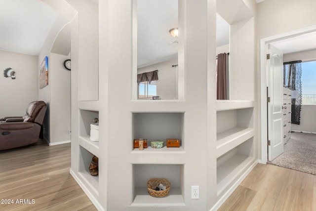 hallway with built in features and light hardwood / wood-style flooring