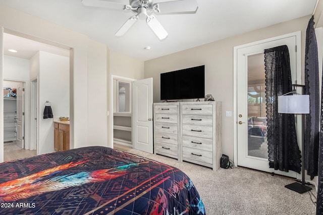 bedroom with ceiling fan, light colored carpet, and connected bathroom